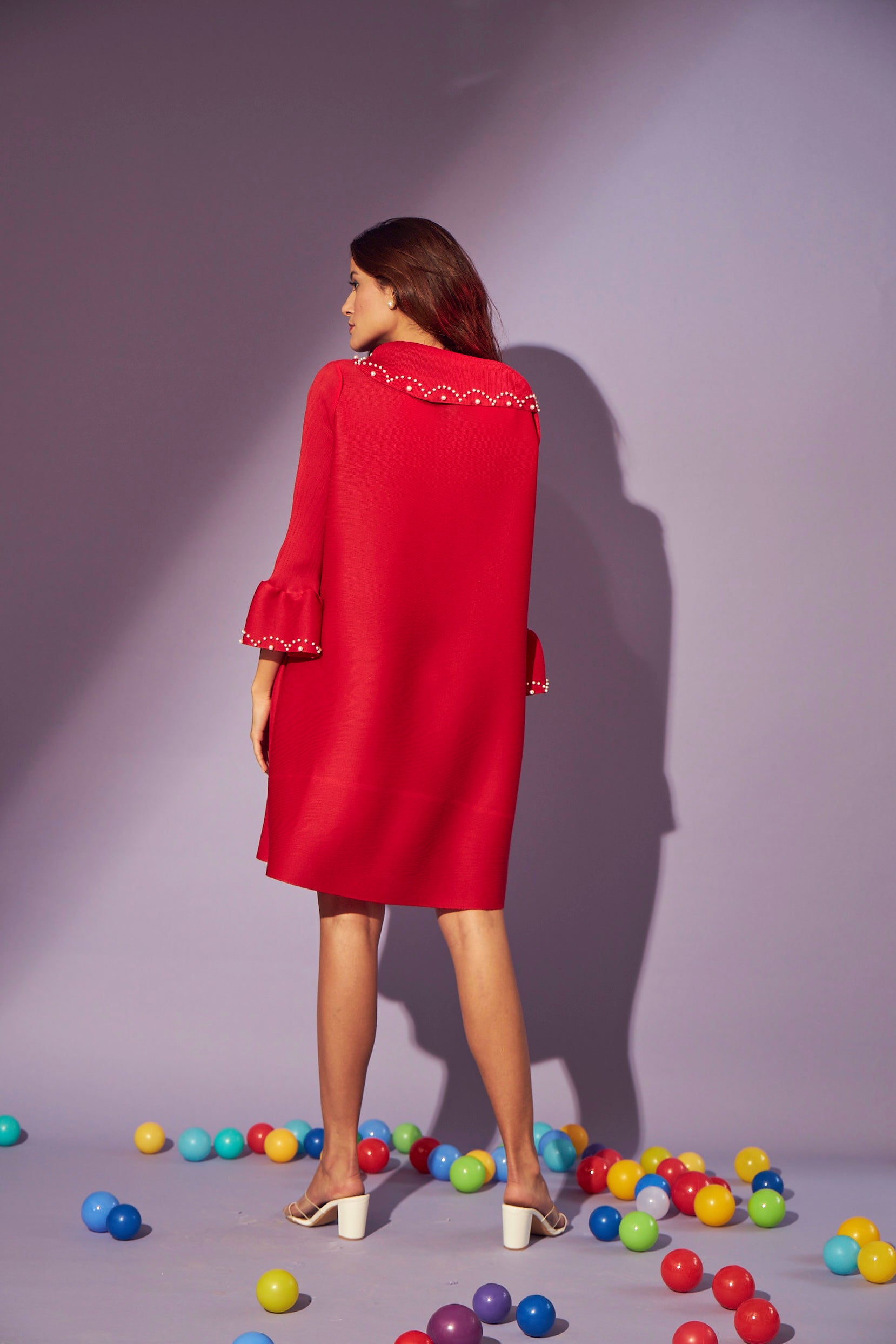 Pearl embellishment on collar and sleeves of pleated red dress