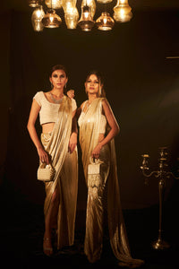 Saia metallic slit saree with an embellished pearl blouse will definitely make you look sassy and elegant in an event.  Tailored to perfection in a metallic fabric, the saree features a slit from the waist level and has an attached palla which creates a great fall.  It comes with a pearl embellished blouse with cap sleeves and deep from the back.